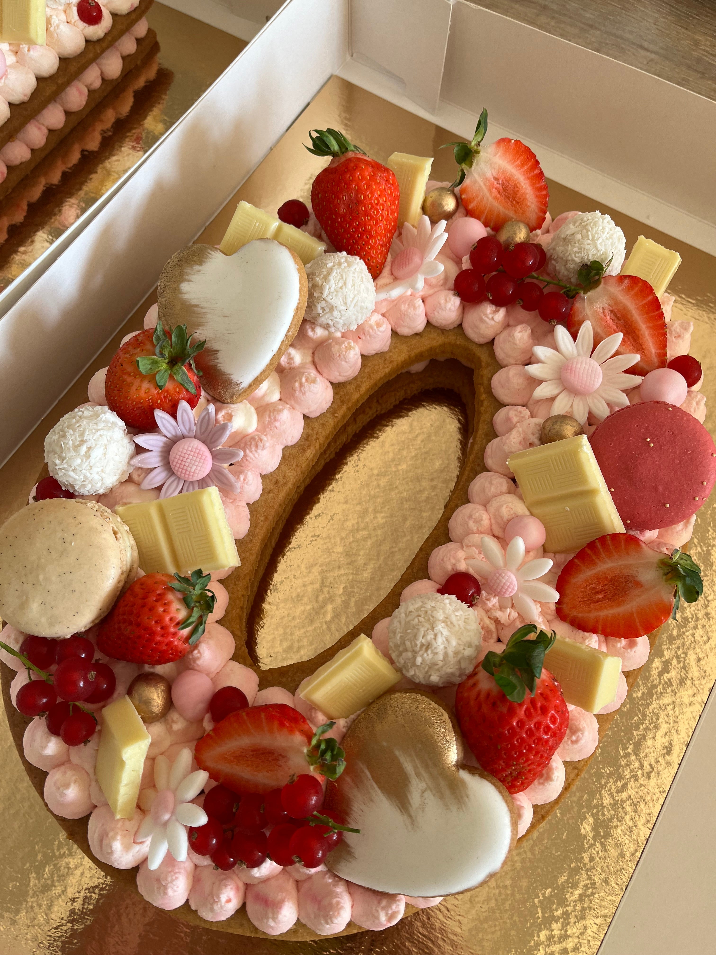 number cake chiffre 0 avec des macaron, une crème chantilly et des fraises